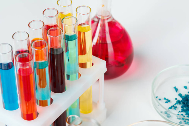 Colored liquids inside lab glassware on white table in laboratory - Foto, Bild