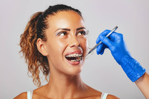Zamknij widok dentysty sprawdzanie szelki z lusterko dentystyczne na pacjentki - Zdjęcie, obraz