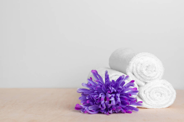 clean soft towels with flower on wooden table - Zdjęcie, obraz