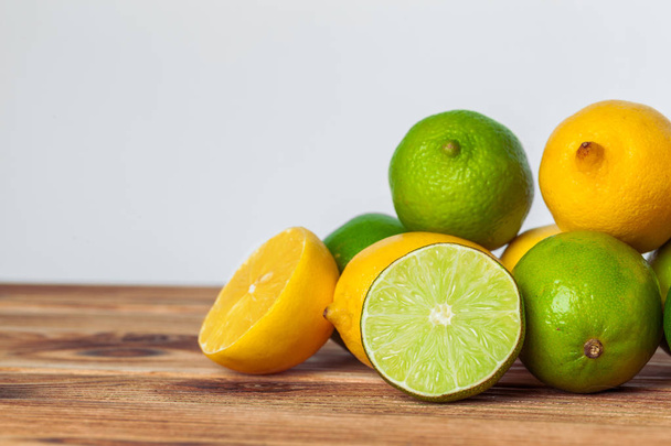 lemons and limes on wooden pad - Foto, imagen