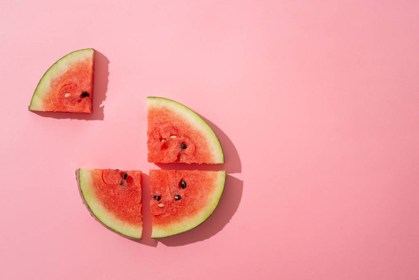 Gesneden watermeloen op de roze achtergrond - Foto, afbeelding