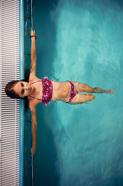 Girl swimming and relaxing in swimming pool - Foto, imagen