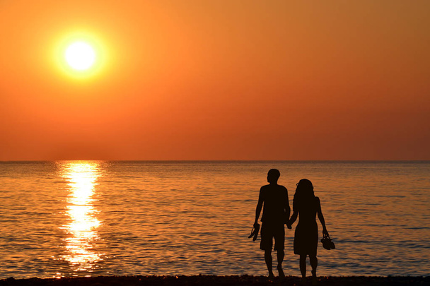 Vista trasera de una silueta de pareja caminando juntos en la playa a
 - Foto, imagen