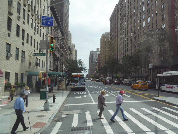 New York, USA - September 2017: Menschen überqueren die Straße vor dem Mount Sinai Hospital an der Madison Avenue in New York City.  - Foto, Bild