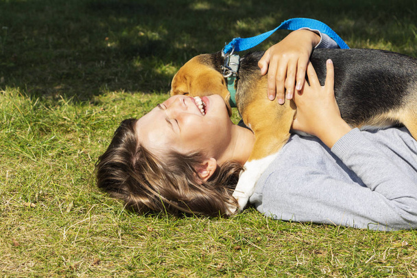 Teenie-Mädchen mit Hund, Hund leckt ihr Gesicht. - Foto, Bild