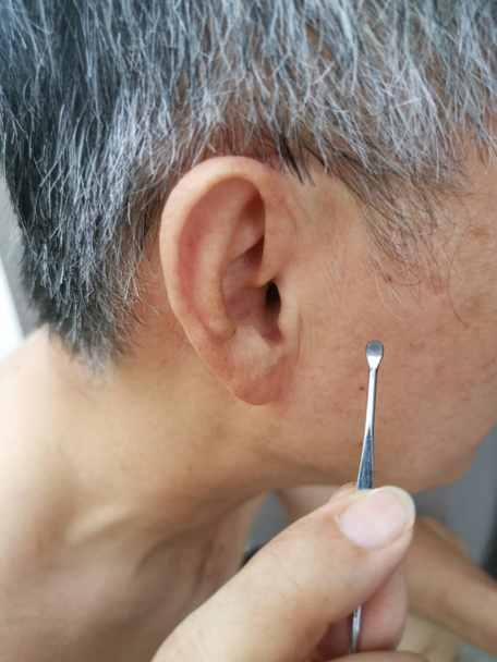 hombre usando kit de limpieza a su cera del oído interno
 - Foto, imagen