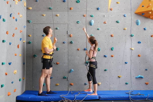Joven hombre y mujer en gimnasio de escalada
 - Foto, imagen