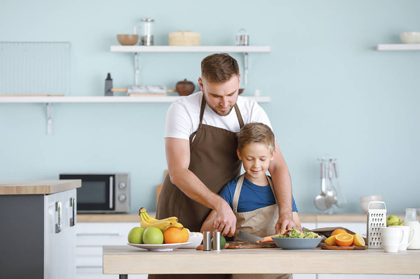 Portrait of happy father and son cooking in kitchen - Photo, Image