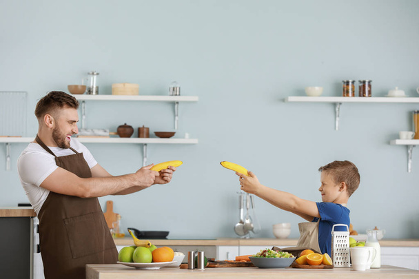 Retrato de padre e hijo divirtiéndose mientras cocinan en la cocina
 - Foto, imagen