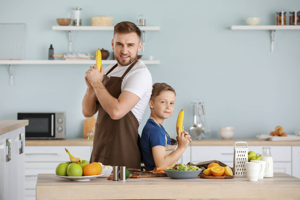 Ritratto di padre e figlio che si divertono mentre cucinano in cucina
 - Foto, immagini