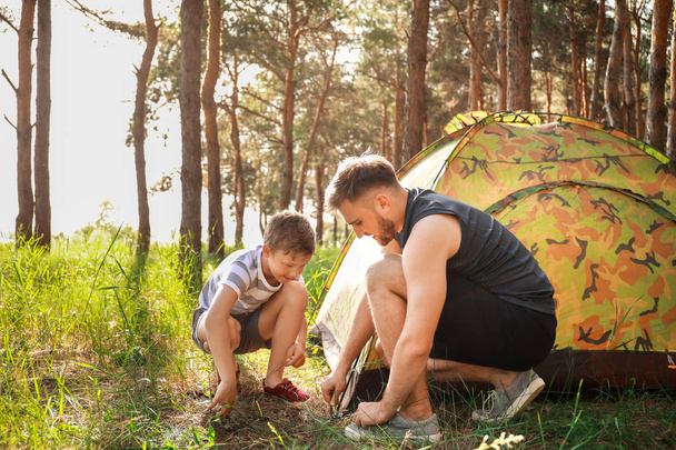 Ο πατέρας και ο γιος του βάζουν σκηνή κατασκήνωσης στο δάσος - Φωτογραφία, εικόνα