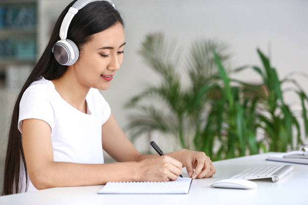 Fiatal ázsiai diák hallgat zenét, miközben készül vizsgára - Fotó, kép