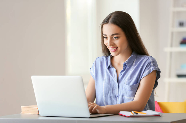 Jeune étudiante avec ordinateur portable se préparant à l'examen à la maison
 - Photo, image