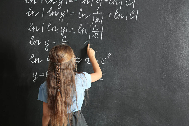 Little schoolgirl near blackboard in classroom - Photo, Image