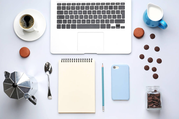 Ordenador portátil con teléfono móvil, notebook, dulces, café y leche sobre fondo blanco
 - Foto, imagen