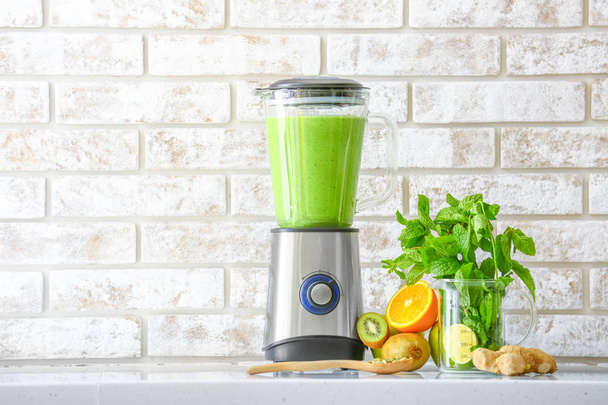 Blender with healthy smoothie and ingredients on table in kitchen - Foto, immagini
