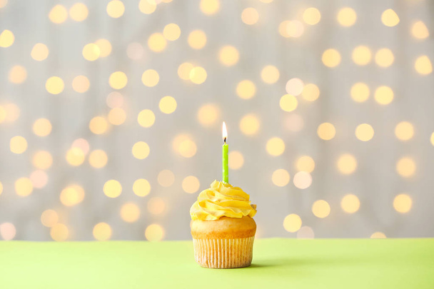 Sabrosa magdalena de cumpleaños en la mesa contra las luces desenfocadas
 - Foto, imagen
