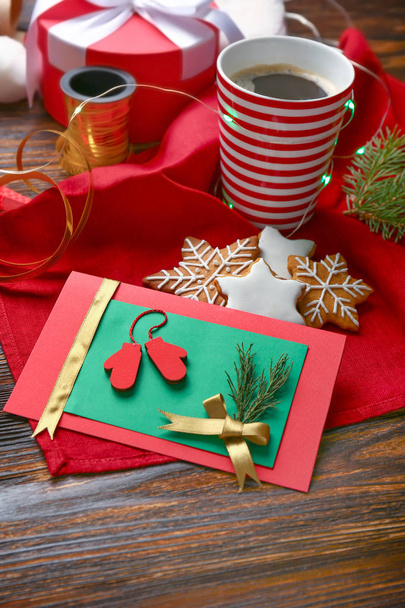 Ručně zhotovený vánoční lístek se sušenkama a kávou na dřevěném stole - Fotografie, Obrázek