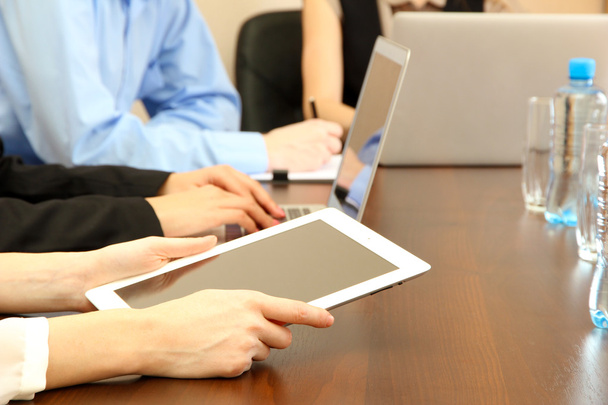 Женские руки с цифровым планшетом на фоне офиса
. - Фото, изображение