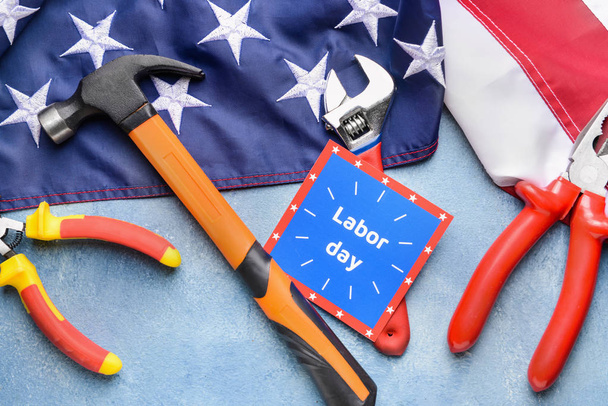 Zestaw narzędzi, karta z tekstem święto pracy i flaga USA na kolorowym tle - Zdjęcie, obraz