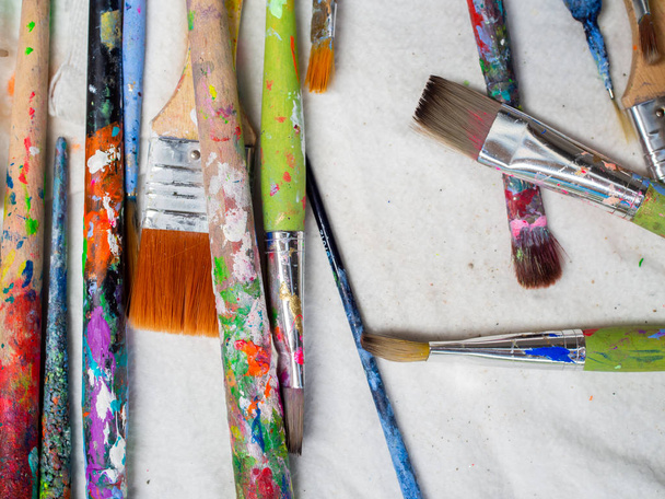 Artist paintbrushes. Flat lay of many artist tools on white fabr - Zdjęcie, obraz