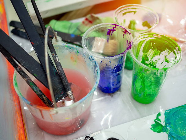 Pincéis de pintura de artista em balde branco de água, cor acrílica em
 - Foto, Imagem