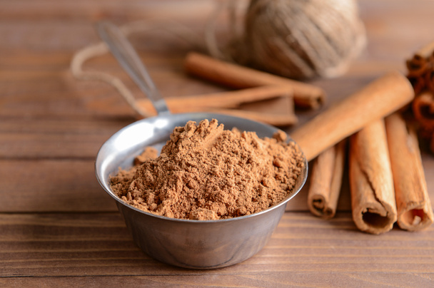 Aromatic cinnamon sticks and powder on wooden table - Photo, Image