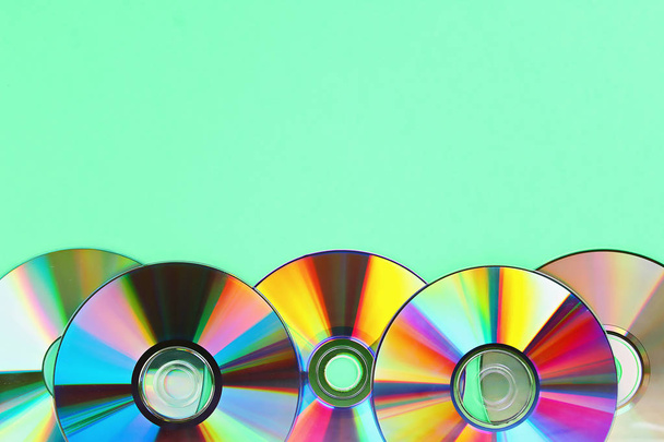 Piles of old and dirty CDs,DVD on pastel mint background. Used and dusty disk with copy space - Фото, изображение