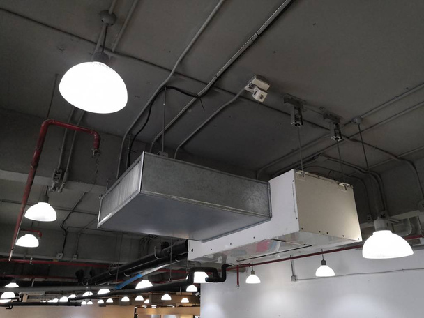 Instalación de unidad de entrega de aire o unidad de bobina de ventilador con conducto y suministro de rejilla de aire en la oficina loft
 - Foto, imagen