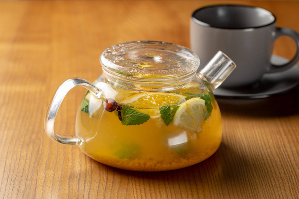 Hot orange with mint tea in glass kettle - Foto, immagini