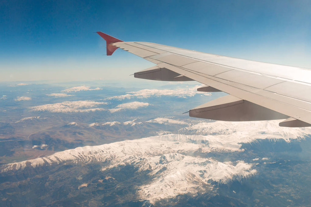 view from the window of the plane that flies over the mountains - 写真・画像