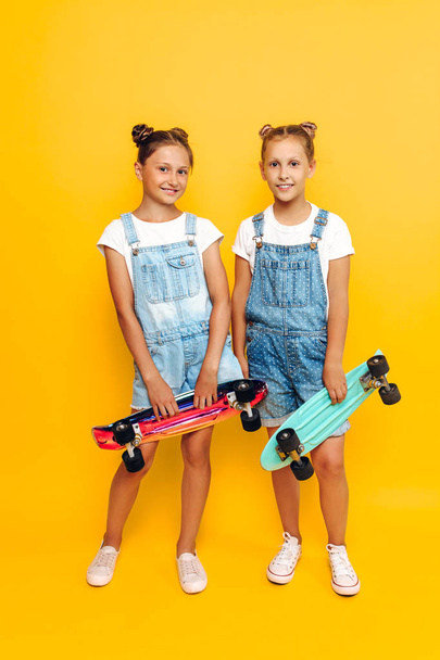 Two teenagers, stylish children posing with skateboards in their - Valokuva, kuva