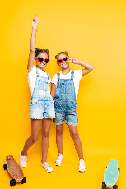 Two teenage girls, stylish girlfriends in sunglasses posing on a - Valokuva, kuva