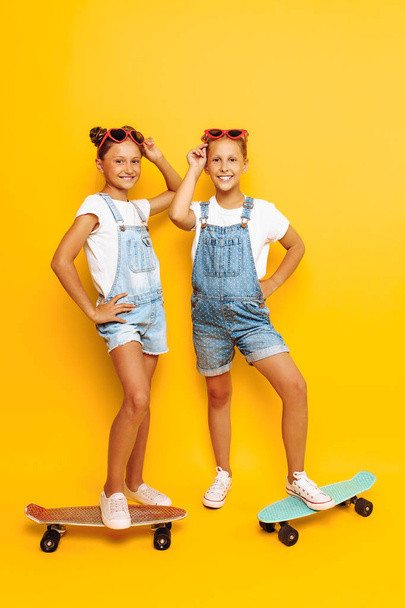 Two teenagers, stylish children posing with skateboards in their - Фото, зображення