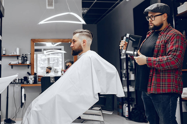 Stylish man sitting in a barbershop - Фото, изображение