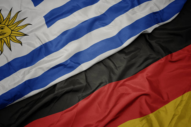 a német zászló színpompás zászlója és Uruguay nemzeti zászlaja. - Fotó, kép