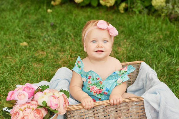 Lasten suojelupäivä, vauva tyttö puistossa istuu korissa kesäpiknikillä.
 - Valokuva, kuva