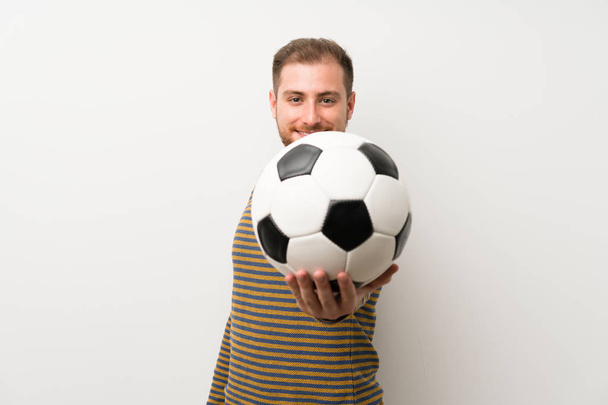 Handsome man over isolated white wall holding a soccer ball - Photo, image