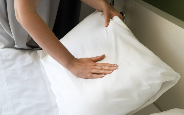 Room service. Woman making bed in hotel room. - Fotó, kép