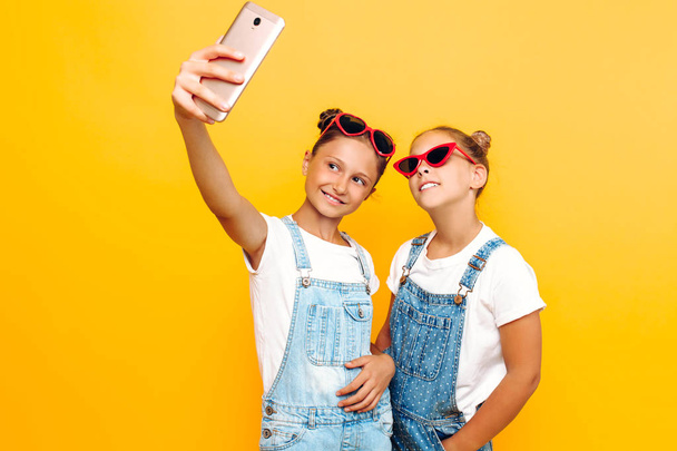 Two teenage girls, girlfriends have a rest and take a selfie on  - Фото, изображение
