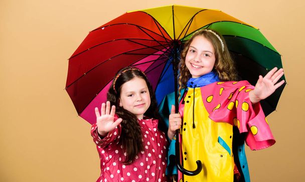 family bonds. Little girls in raincoat. happy little girls with colorful umbrella. rain protection. Rainbow. autumn fashion. cheerful hipster children, sisterhood. No more rain. Snapping memories - Фото, изображение