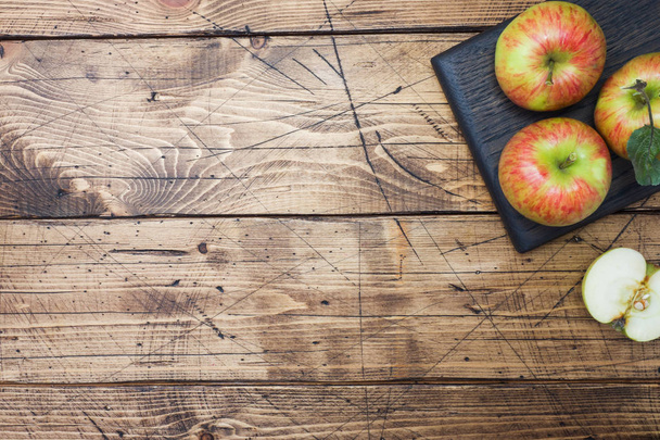 Red apples on a wooden table. Apples cut into slices. Copy space. - Foto, Imagem
