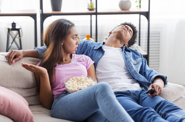 Bored guy sleeping next to girlfriend while watching movie together - Photo, Image