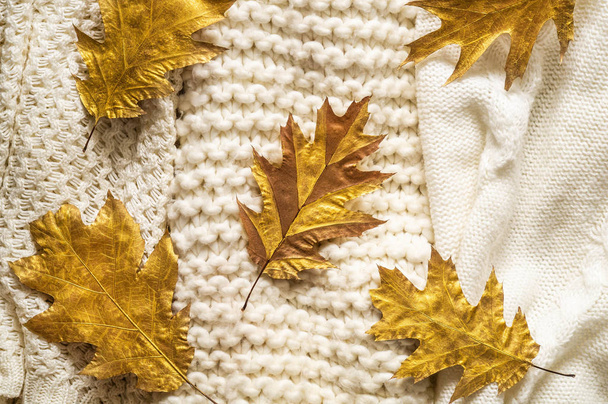 Fondo de otoño con suéteres calientes. Montón de prendas de punto con hojas de otoño, fondo cálido, prendas de punto, espacio para el texto
 - Foto, imagen