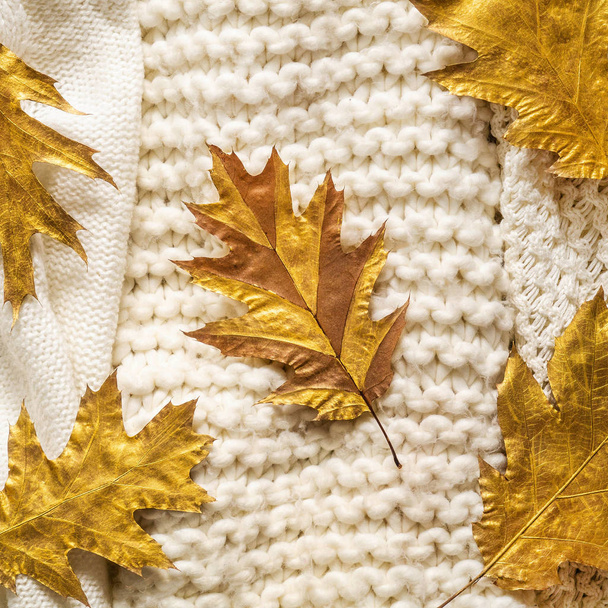 Fondo de otoño con suéteres calientes. Montón de prendas de punto con hojas de otoño, fondo cálido, prendas de punto, espacio para el texto
 - Foto, Imagen