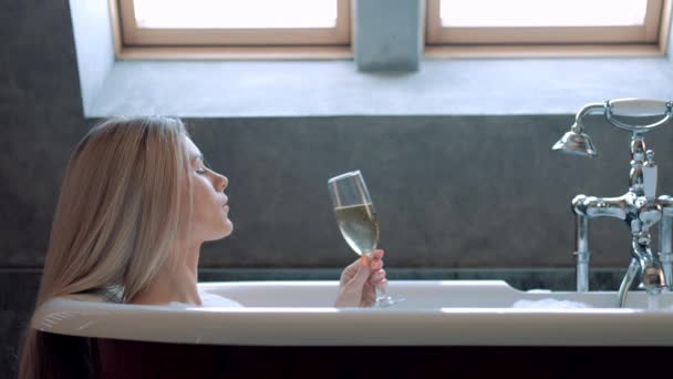 Beautiful blond woman lies in a bath with foam and relaxes. - Metraje, vídeo