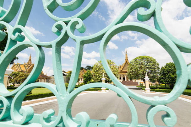 View over Phnom Penh Royal Palace through the iron entrance gate on sunny day, Cambodia - Photo, Image