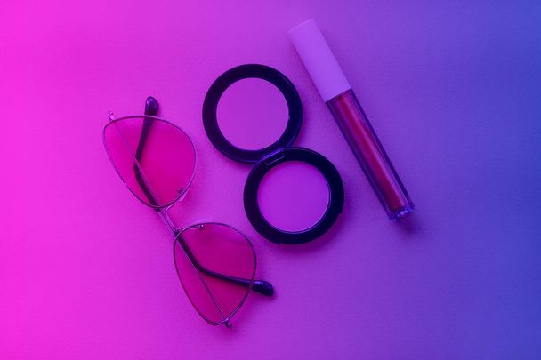 Rouge and sunglasses are toned on trendy neon colors  pink, violet and blue. Makeup and fashion concept. Flat lay  - Photo, Image