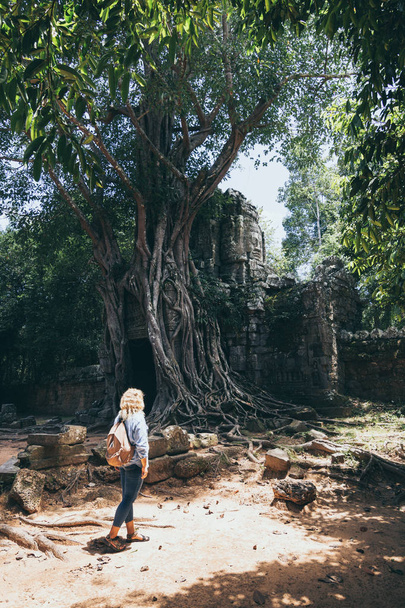 Καυκάσια ξανθιά γυναίκα που ανακαλύπτει τα ερείπια του συγκροτήματος ναού Angkor Wat στο Σιέμ Ριπ, Καμπότζη - Φωτογραφία, εικόνα