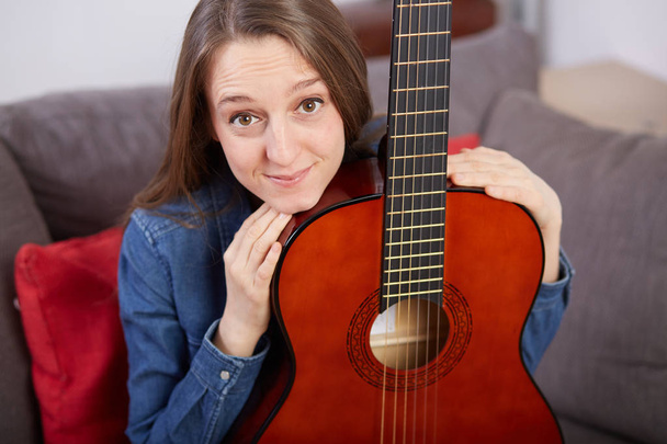 woman play guitar at home - Foto, afbeelding